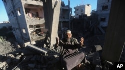 2023年12月15日，一名巴勒斯坦人在以色列袭击加沙地带拉法的住宅楼后作出反应。（美联社照片）