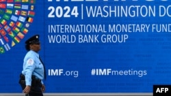 ওয়াশিংটন ডিসিতে আইএমএফ সদর দফতরের পাশ দিয়ে হেঁটে যাচ্ছে এক নিরাপত্তা রক্ষী। ১২ এপ্রিল, ২০২৪। 