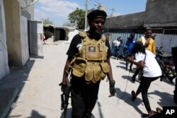 Jimmy Chérizier, a former elite police officer known as Barbecue who leads the G9 and Family gang, walks away after speaking to journalists in the Delmas 6 neighborhood of Port-au-Prince, Haiti, Monday, March 11, 2024. (AP Photo/Odelyn Joseph)