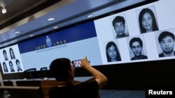 香港当局在记者会上公布被通缉的五名活动人士的照片资料。（2023年12月14日）