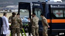 
Wanajeshi wakimbeba kwenye gari la wagonjwa raia wa Ugiriki aliyejeruhiwa mguu baada ya kuhamishwa kutoka Sudan, tarehe 25 Aprili 2023. Picha na Aris Messinis / AFP.
