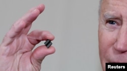 拜登总统在白宫签署有关解决全球半导体芯片短缺的行政令期间手拿芯片发表讲话。（2021年2月24日）