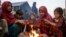 FILE - Displaced Afghan children warm themselves at a fire in a camp near the Torkham Pakistan-Afghanistan border crossing in Torkham, Afghanistan, Nov. 4, 2023, following their repatriation from Pakistan.