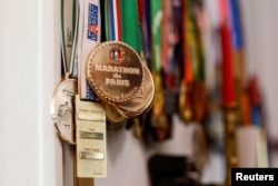 The medals of French runner Barbara Humbert, 83, long-distance world record winner who dreams to run the Olympic Marathon For All at the Paris 2024 Olympics and Paralympics Games, are pictured in her house in Eaubonne near Paris, France April 26, 2023. (REUTERS/Gonzalo Fuentes)