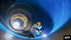 中国江苏连云港一家工厂的工人在焊接一个风井。（2023年5月31日）