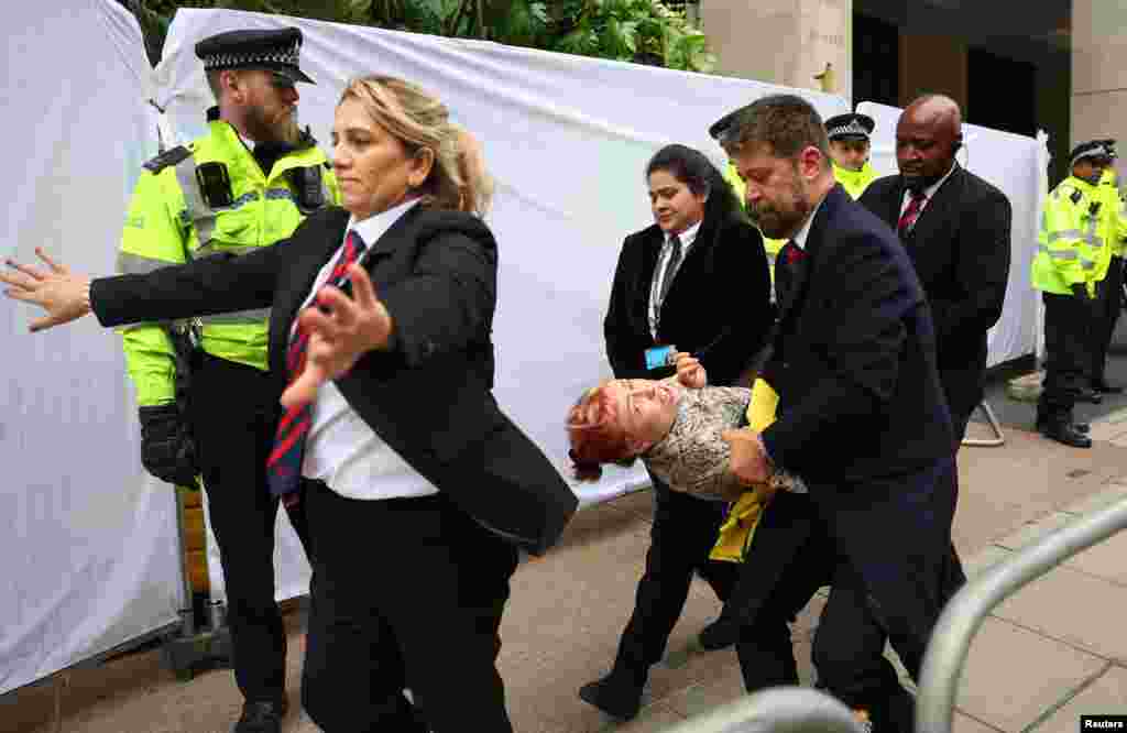 Police officers and security staff remove a demonstrator from the venue of the Energy Intelligence Forum, as Oily Money Out protests take place outside, in London. REUTERS/Toby Melville&nbsp;