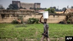 Kijana akipita karibu na reali iliyoko Kampala. Picha na LUIS TATO / AFP