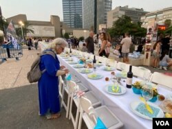 位处特拉维夫市中心、紧邻以色列国防部的特拉维夫艺术博物馆前广场,一个安息日餐桌及其空寂座椅摆饰象征被绑架人质的家庭生活被颠覆迫害而成虚空。(美国之音/赖素芬)