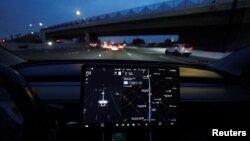 FILE - A Tesla Model 3 vehicle drives on autopilot along the 405 highway in Westminster, California, U.S., March 16, 2022. (REUTERS/Mike Blake)