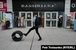 一名男子滚着汽车轮胎经过霍尔果斯的商店。