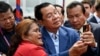 FILE - Cambodia's Prime Minister Hun Sen (C) takes selfies with a supporter during the inauguration ceremony of the Bakheng-1 water treatment plant in Phnom Penh on June 19, 2023.
