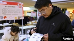 23岁的张百川（音译）在中国河北省石家庄市的招聘会上查看招工广告。（2024年2月24日）