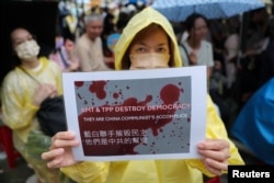 台湾民众聚集在台北的立法院外，一名女子手举表达自己政治意愿的标语牌。(2024年5月24日)