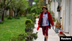 Barbara Humbert, 83, long-distance world record winner in her category who dreams to run the Olympic Marathon For All at the Paris 2024 Olympics and Paralympics Games, walks in the garden of her house in Eaubonne near Paris, France April 26, 2023. (REUTERS/Gonzalo Fuentes)