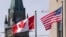 FILE - The Canadian and US flags are displayed on lampposts March 22, 2023, near Parliament Hill in Ottawa, Ontario. 
