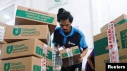 An employee packs goods at Goto's e-commerce unit Tokopedia's warehouse in Jakarta, Indonesia, August 31, 2022. REUTERS/Ajeng Dinar Ulfiana