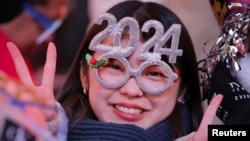 一名女子戴着2024年的头饰在纽约时报广场参加新年庆祝活动。（2023年12月31日）