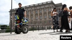 সেগওয়েতে সুইডেনের পার্লামেন্ট ভবনের সামনে টহল দিচ্ছেন একজন পুলিশ অফিসার। ১৭ আগস্ট, ২০২৩। (ফাইল ছবি) 