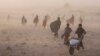 Afghans receive aid while a sandstorm rages at the Chahak village, after an earthquake in Zenda Jan district in Herat province, western of Afghanistan, Oct. 12, 2023. The Afghan Taliban has reportedly blocked earthquake-related aid from Pakistan over a post on social media.