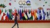 A man walks near flags ahead of G20 Summit in New Delhi, Sept. 8, 2023. 