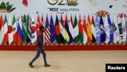নয়াদিল্লিতে জি-২০ শীর্ষ সম্মেলনের আগে বিভিন্ন দেশের পতাকার পাশ দিয়ে হেঁটে যাচ্ছেন এক ব্যক্তি। ৮ সেপ্টেম্বর, ২০২৩। 