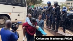 A member of Zimbabwe’s main opposition the Citizens’ Coalition for Change, or Triple C, with a broken leg cries as she is carried into Harare Magistrates Court in Zimbabwe, on June 18, 2024.