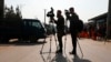 FILE - Afghan journalists film in Kabul, Afghanistan, Feb. 9, 2021. A Taliban-controlled state broadcaster muted microphones and refused to show images of a female journalist asking a question at a news conference in Kabul on Aug. 27, 2024.