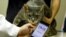 อาจารย์มหาวิทยาลัยนิฮอน คาซูยะ เอดะมูระ วัย 49 ปี ใช้แอปฯ 'CatsMe!' ที่ใช้เอไอมาช่วยวินิจฉัยอาการป่วยของแมว 11 มิ.ย. 2024 (REUTERS/Issei Kato)
