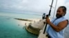 FILE - A man fishes on a bridge on Tarawa atoll, Kiribati, on March 30, 2004. 