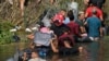 FILE - Migran Venezuela Luis Parra (ketiga dari kanan), bergabung dengan migran lainnya menyeberangi sungai Rio Grande, terlihat dari Matamoros, Meksiko, 10 Mei 2023. (AP/Fernando Llano)