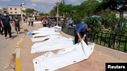 লিবিয়ার দেরনায় শক্তিশালী ঝড় এবং ভারী বৃষ্টিপাতের পর এক ব্যক্তি একটি মৃতদেহ দেখছেন। ১২ সেপ্টেম্বর, ২০২৩।