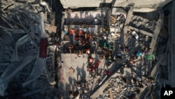 Wa-Palestina wakifukua vifusi vya majengo yaliyoshambuliwa na ndege za Israel kwenye kambi ya wakimbizi ya Al Shati, Oct. 12, 2023. 