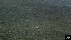 FILE - A Kenyan army helicopter flies over forest near Kismayo, Somalia, on Oct. 2, 2012, where allied African troops were fighting al-Shabab Islamist rebels. Al-Shabab limits tree cutting in areas of Somalia it controls, in part to hide it from aerial attack.