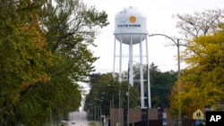 资料照片：密歇根州本顿港的一名行人穿过靠近该市水塔的街道。(2021年10月22日）