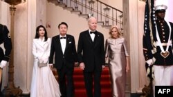 Rais wa Korea Kusini Yoon Suk Yeol (wa pili kushoto) na mkewe Kim Keon Hee (kushoto), Rais wa Marekani Joe Biden (wa pili kulia) na Mke wa Rais wa Marekani Jill Biden (kulia) wakiwasili katika chakula cha jioni huko, tarehe 26 Aprili 2023. Picha na Brendan SMIALOWSKI / AFP. 