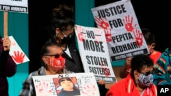 FILE - Family members of missing and slain Native Americans gathered to watch New Mexico Gov. Michelle Lujan Grisham sign legislation during a ceremony in Albuquerque, NM, Feb. 24, 2022. 