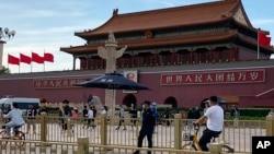 资料照片：北京天安门前一名安全人员在监视过往居民。（2023年6月4日）