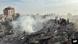 FILE - Palestinians look for survivors following Israeli airstrike in Nusseirat refugee camp, Gaza Strip, Oct. 31, 2023.