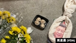 悼念李克强现场，习画像上套了一条围巾做的绞索和一盒包子。（周星晨）