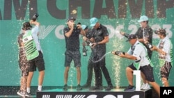 FILE - Team champions David Puig, Sebastián Muñoz, Mito Pereira, Captain Joaquín Niemann of Torque GC and their caddies celebrate on stage May 28, 2023, in Sterling, Virginia. 