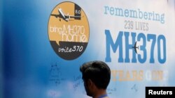 Seorang pria menulis di papan pesan untuk penumpang pesawat Malaysia Airlines Penerbangan MH370 yang hilang, pada acara peringatan tahunan kelima di Kuala Lumpur, Malaysia, 3 Maret 2019. (Foto: REUTERS/Lai Seng Sin)