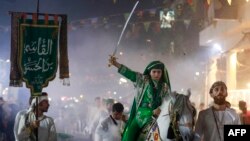 আশুরার আগে, মধ্য বাগদাদে শোকপালনে অংশ নিয়েছে এক ইরাকি শিয়া বালক; ২৭ জুলাই, ২০২৩।
