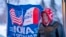 FILE - A man stands next to a flag that reading "Iowa for Trump" in Urbandale, Iowa, Jan. 11, 2024. Voters in the state are participating in caucuses on Jan. 15, 2024, that launch the Republican presidential nomination process.