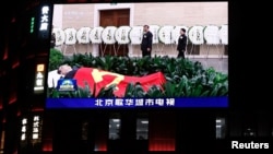 电视屏幕上播放的中国国家主席习近平和妻子彭丽媛送别中国前总理李克强的画面。