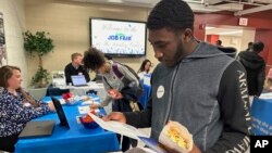 Job seeker Johannes Oveida looks over a brochure at a job fair at Lehigh Carbon Community College in Allentown, Pennsylvania, March 7, 2024. 