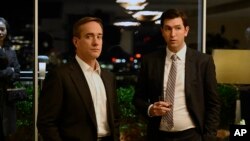 Akte Matthew Macfayden ki jwe Tom Wambsgans ( a goch) epi Nicholas Braun, ki jwe Greg Hirsch, nan yon sen seri televize "Succession" rezo HBO a. 