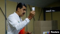 Presiden Venezuela Nicolas Maduro menunjukkan surat suaranya dalam pemilihan referendum terkait status wilayah Esequiba, di tempat pemungutan suara di Caracas, Venezuela, pada 3 Desember 2023. (Foto: Reuters/Leonardo Fernandez Viloria)