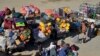 Afghan refugees sit beside their belongings at a registration center, upon their arrival from Pakistan near the Afghanistan-Pakistan border in the Spin Boldak district of Kandahar province, Nov. 20, 2023.