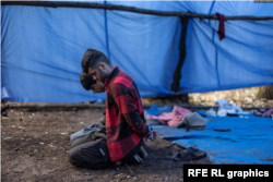 9月12日塞尔维亚苏博蒂察市附近的匈牙利边境附近的临时营地里，被拘留的移民双手戴着手铐跪坐在地上。