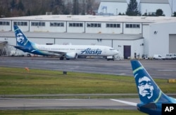 Alaska Airlines N704AL, a 737 Max 9 which made an emergency landing at Portland International Airport after a part of the fuselage broke off mid-flight on Friday, in Portland, Ore., Jan. 6, 2024. (AP Photo/Craig Mitchelldyer)
